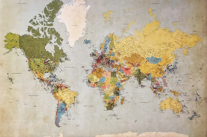 Colourful vintage-style world map covered with coloured push pins marking locations across continents